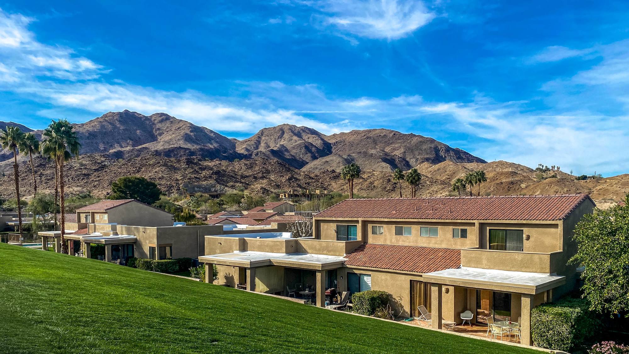 Sommerset's two-story residences with red-tile roofs and a wide green lawn, set against the Santa Rosa Mountains in South Palm Desert.